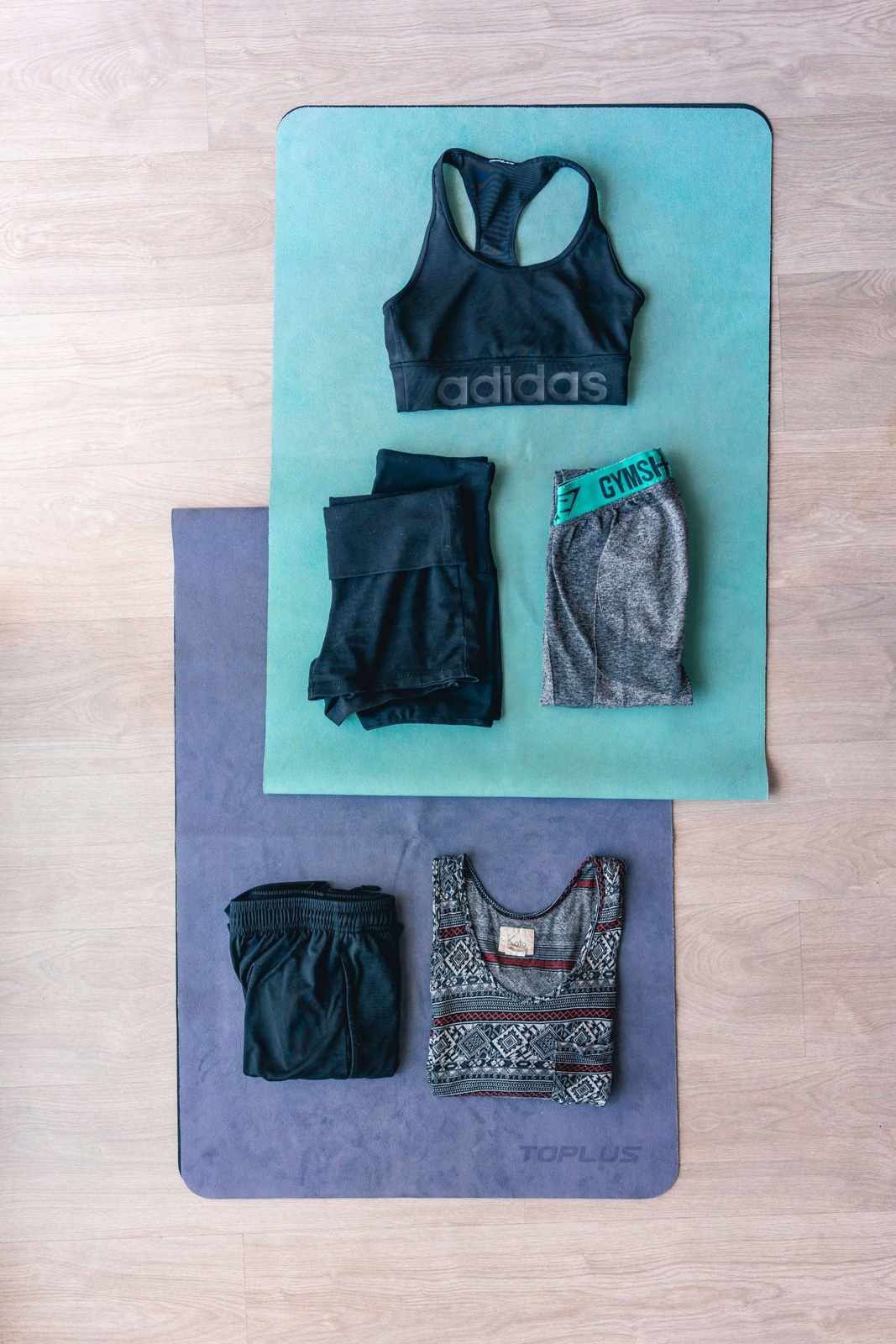 Sports tops and shorts laid out in two coordinated sets.