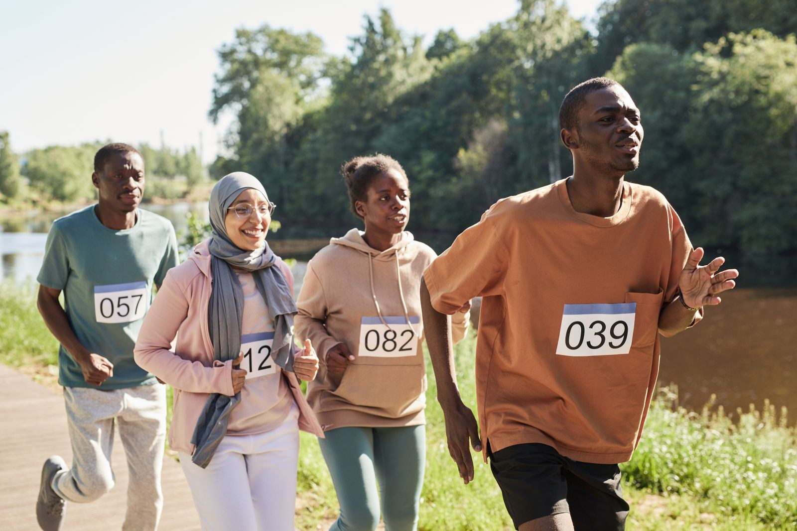 Participants with numbered bibs take part in a park running event.
