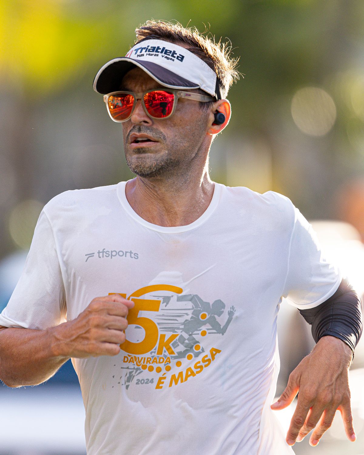 A runner wearing a visor and a race bib marked 5K.