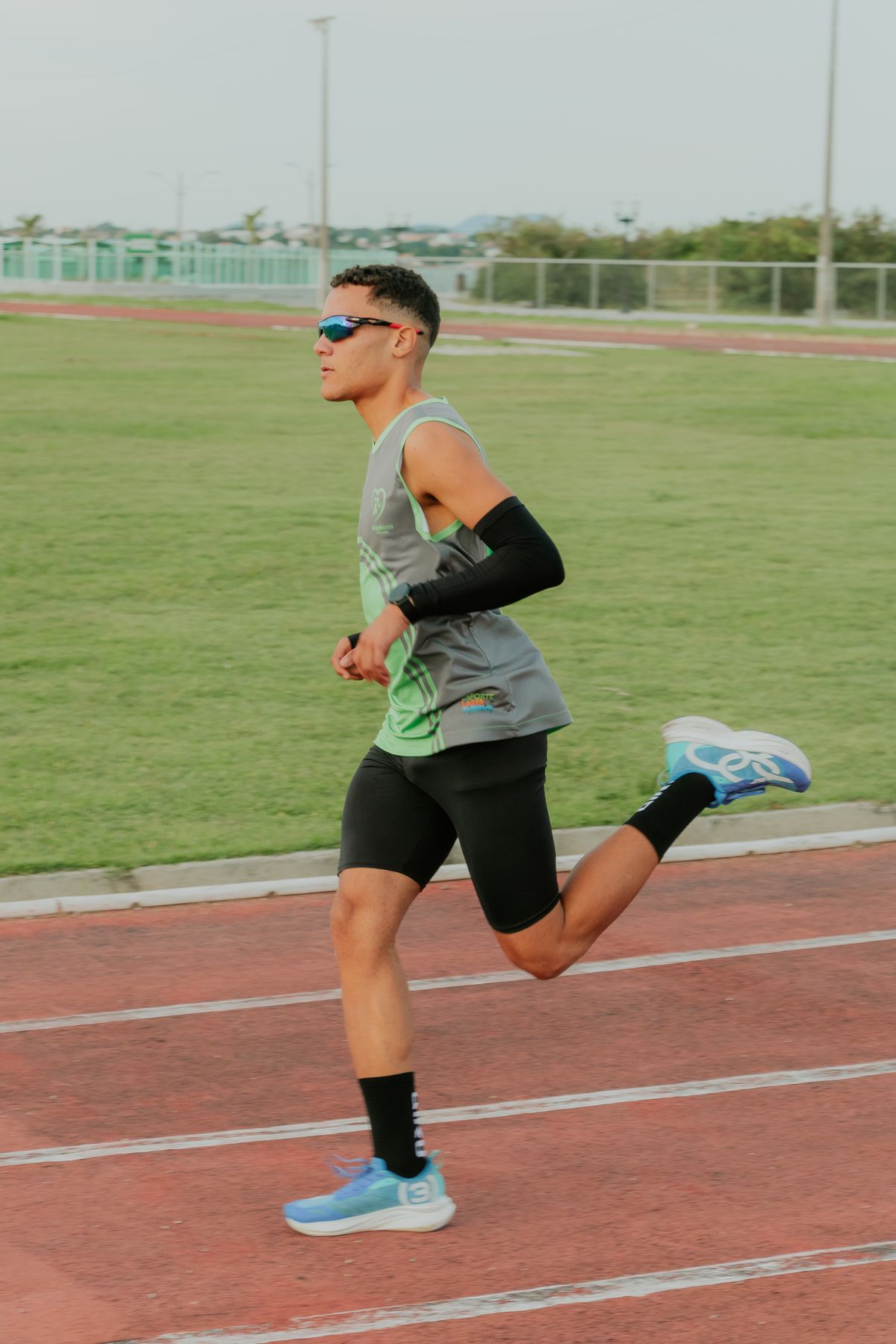 An athlete running in a marked lane on an outdoor track.