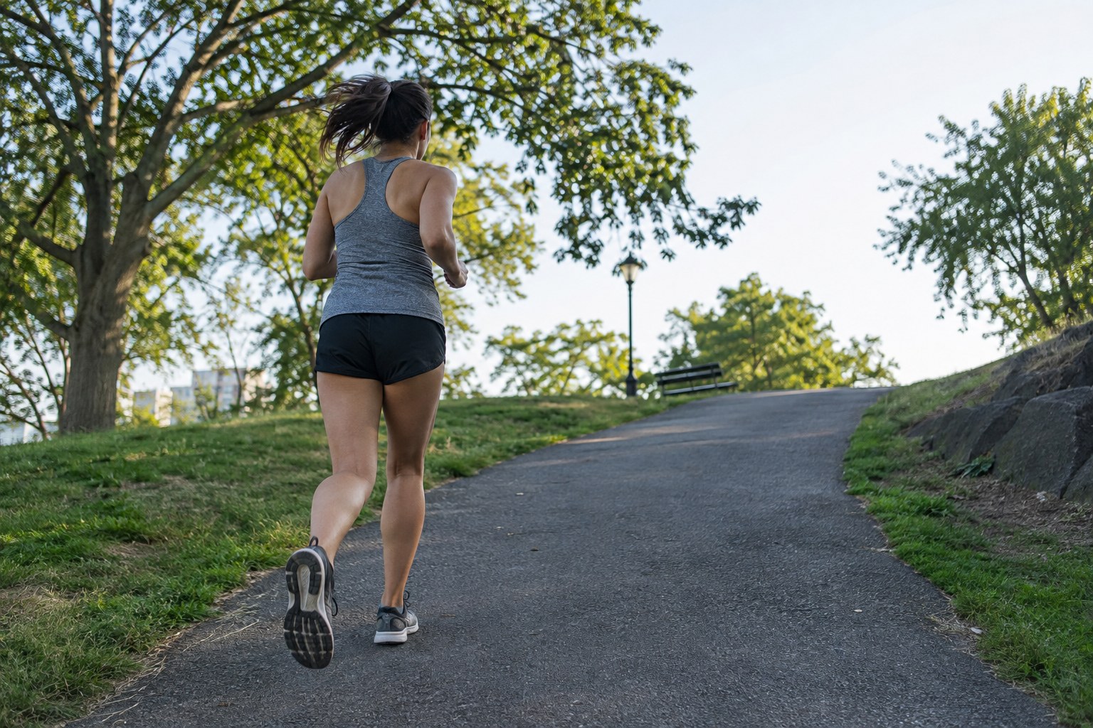 A runner approaches a modest slope in a park.
