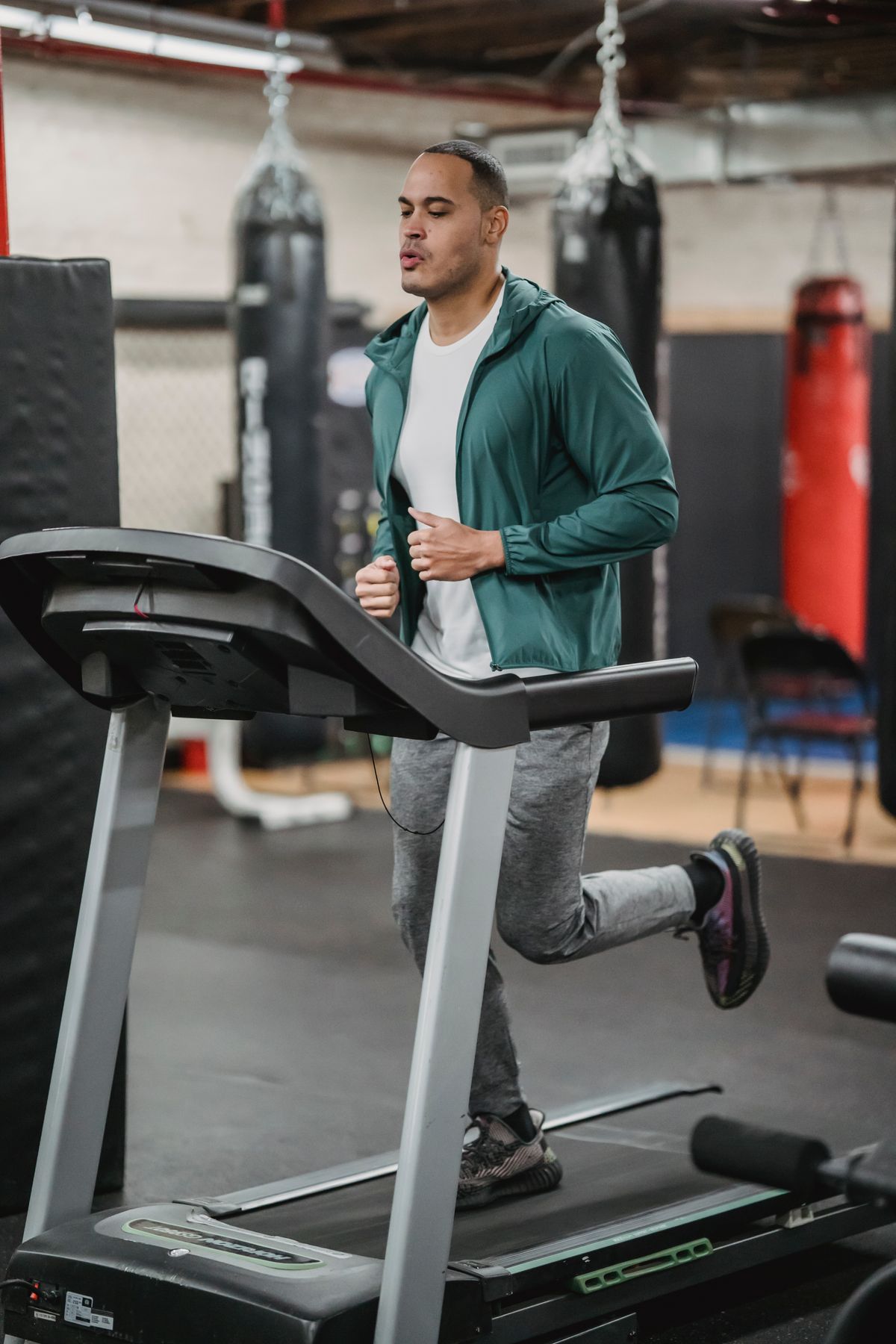 A man runs on a treadmill with its control panel in front of him.