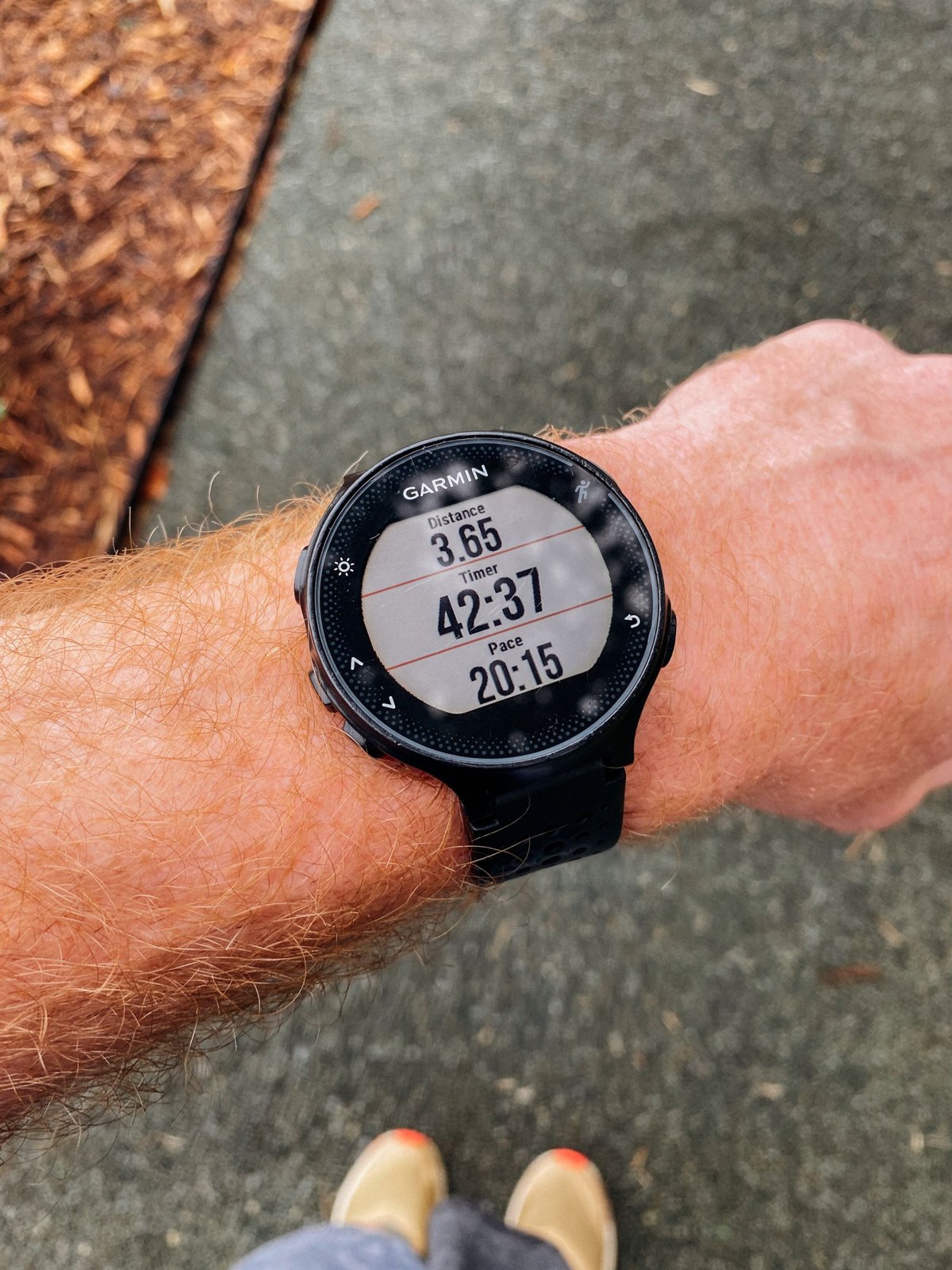 A round running watch displays time, distance and pace on one screen.