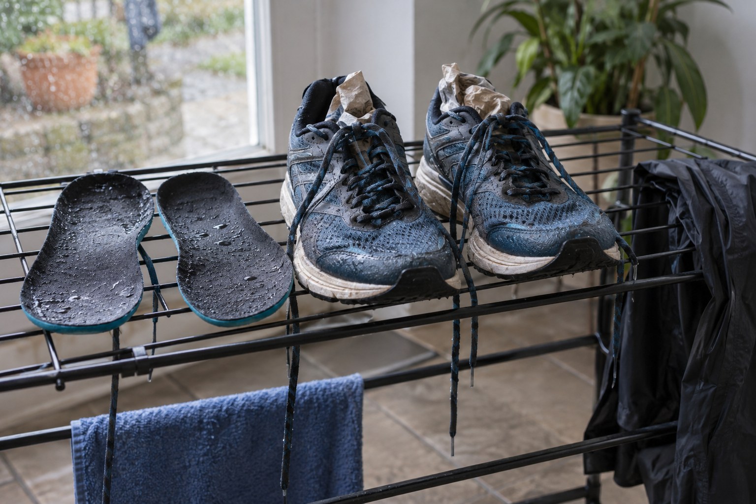 Running shoes dry with insoles removed on a ventilated rack.