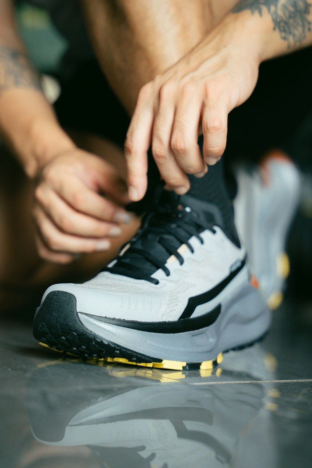 Hands adjust the laces of a running shoe before use.
